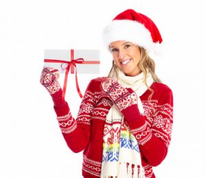 Happy woman with christmas present isolated over white background.